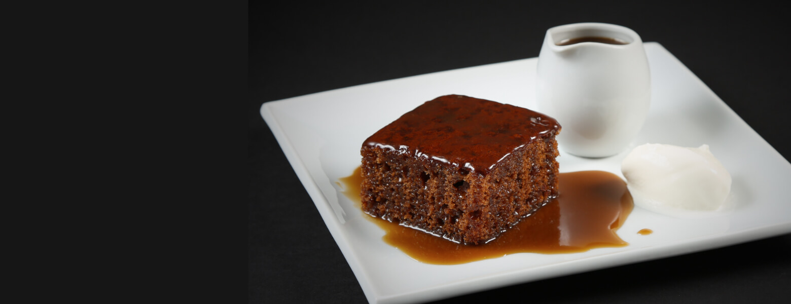 sticky toffee pudding on a plate with ice cream